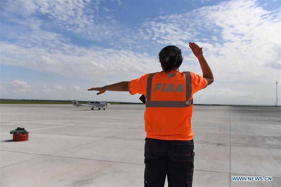 Deng Yun guides an aircraft to a specific place at the Chagan Lake airport in Songyuan, northeast China\'s Jilin Province, July 17, 2018. Deng was born in 1991. She is an aircraft maintenance technician of an aviation academy in Jilin. The young female engineer and other nine colleagues are in charge of training plane maintenance at the airport. To ensure the flight safety, they need to check more than 100 items before a plane takes off. (Xinhua/Zhang Nan)