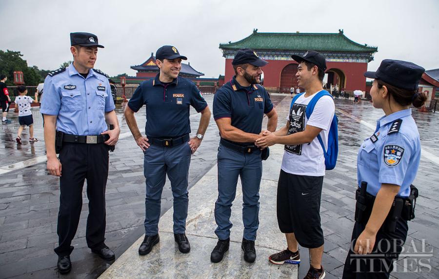 A Chinese tourist shakes hands with an Italian policeman at the Tiantan, better known as the Temple of Heaven in Beijing on Tuesday. (Photo: Lihao/ GT)