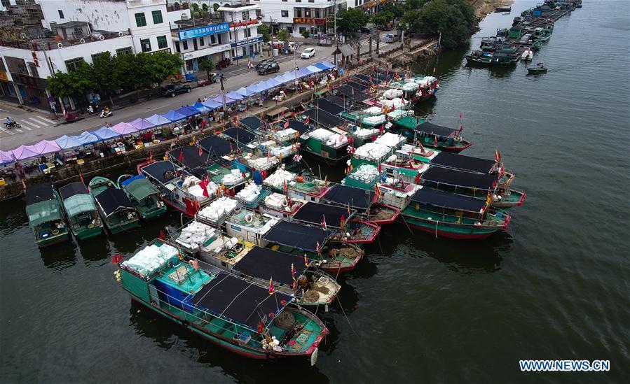 Fishing boats berth at a harbor in Qionghai, south China\'s Hainan Province, July 17, 2018. Ferry services on the Qiongzhou Strait in south China have been halted as of Tuesday afternoon as a typhoon is fast approaching the southern provinces of Hainan and Guangdong, local authorities have said. Son-Tinh, the ninth typhoon this year, is expected to make landfall in Hainan and Guangdong on Wednesday morning, according to China\'s National Meteorological Center. (Xinhua/Yang Guanyu)