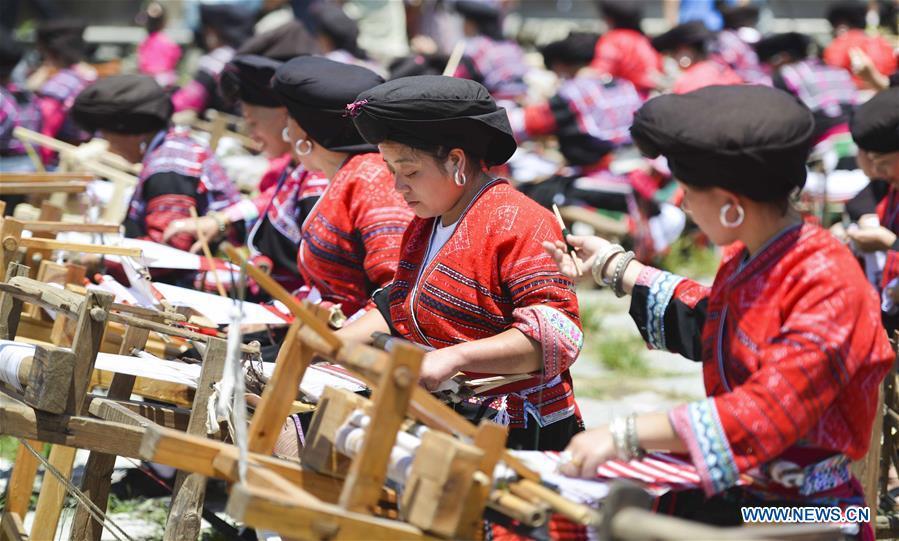 Women of Yao ethnic group present the skills of making folk costumes in Longji Township of Guilin, south China\'s Guangxi Zhuang Autonomous Region, July 18, 2018. Local people of Yao ethnic group on Wednesday celebrated annual \