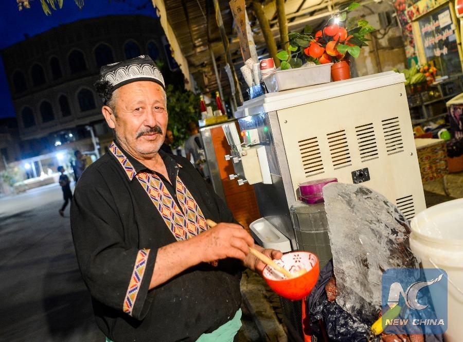 A Uygur man prepares a popular shaved ice dessert in Kashgar on July 11. (Photo: Xinhua/Zhao Ge)