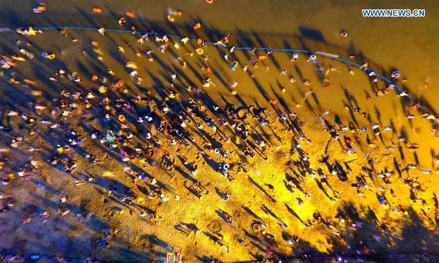 Aerial photo taken on July 18, 2018 shows people on the beach in Liuzhou City, south China\'s Guangxi Zhuang Autonomous Region. (Xinhua/Li Hanchi)