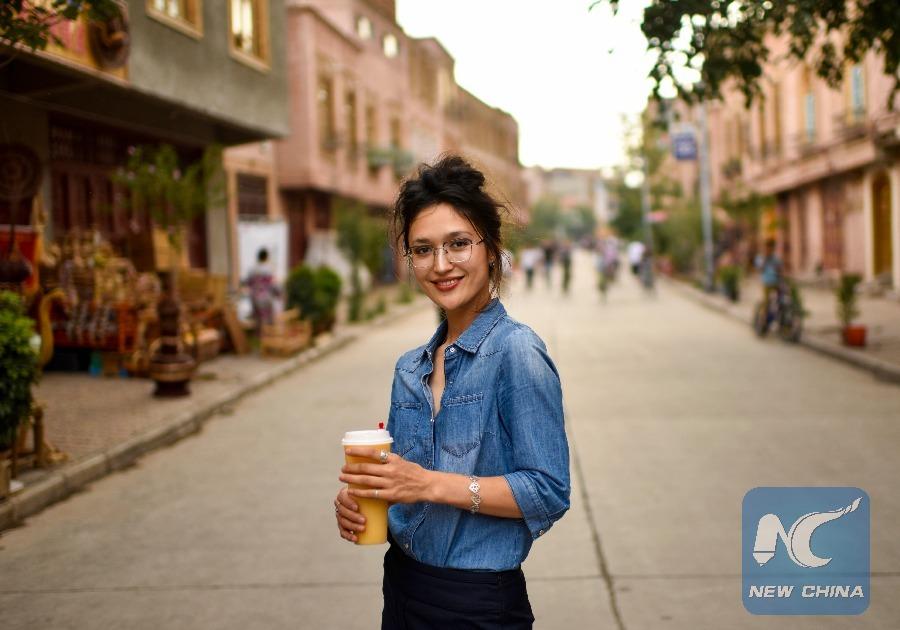 Alia stands on the street in Kashgar where she has just opened a juice shop. (Photo: Xinhua/Zhao Ge)