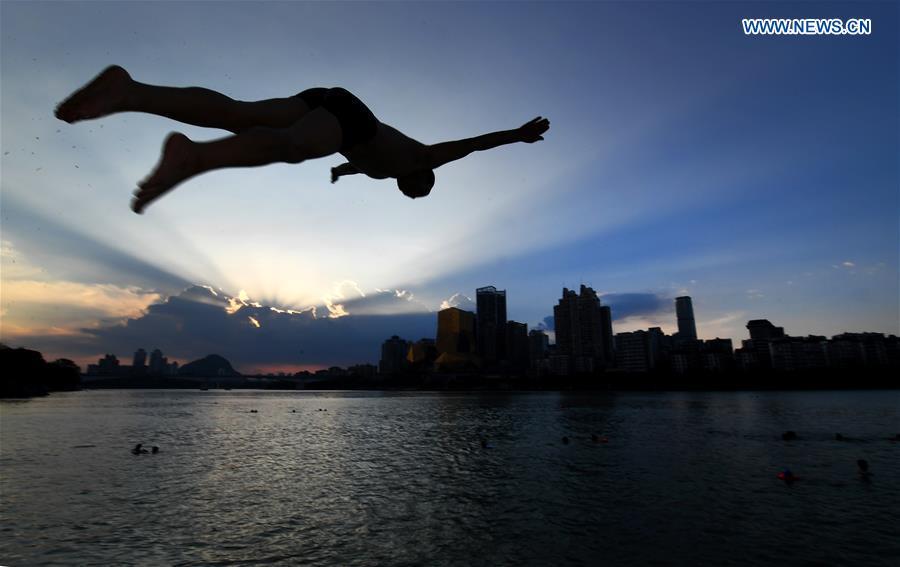 A man jumps into water to cool off in Zhaojiajing area in Liuzhou City, south China\'s Guangxi Zhuang Autonomous Region, July 18, 2018. (Xinhua/Li Hanchi)
