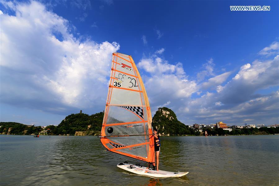 A sailboarder practices in Jinshajiao area in Liuzhou City, south China\'s Guangxi Zhuang Autonomous Region, July 18, 2018. (Xinhua/Li Hanchi)