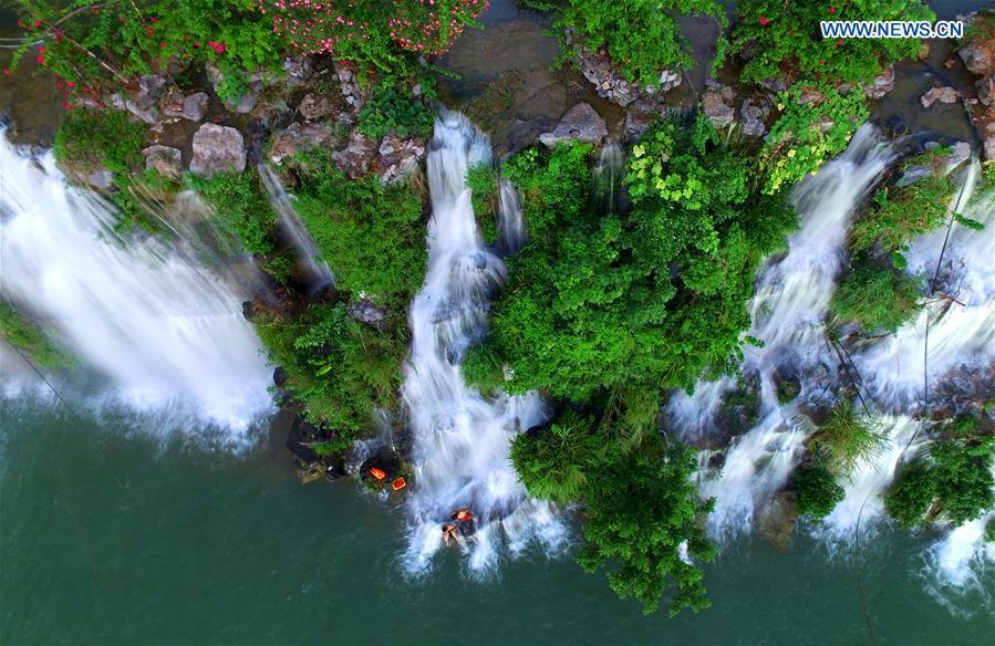 People cool off at waterfalls of Panlong Mountain in Liuzhou City, south China\'s Guangxi Zhuang Autonomous Region, July 18, 2018. (Xinhua/Li Hanchi)