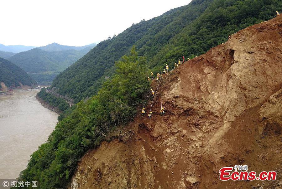 Rescuers clean up a landslide that affected the Baoji-Chengdu Railway after heavy rain in Lueyang County, Northwest China’s Gansu Province, July 18, 2018. More than 1,000 people have worked 24 hours to clean up the landslide and resume operations as soon as possible. (Photo/VCG)