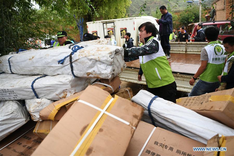 Volunteers convey disaster relief materials at flood-hit Chenhe Village of Dongxiang Autonomous County in Linxia Hui Autonomous Prefecture, northwest China\'s Gansu Province, July 20, 2018. About 1.08 million people in Gansu Province were affected by rain-triggered floods, with 12 deaths, four people missing and 27,000 people evacuated. (Xinhua/Chen Bin)