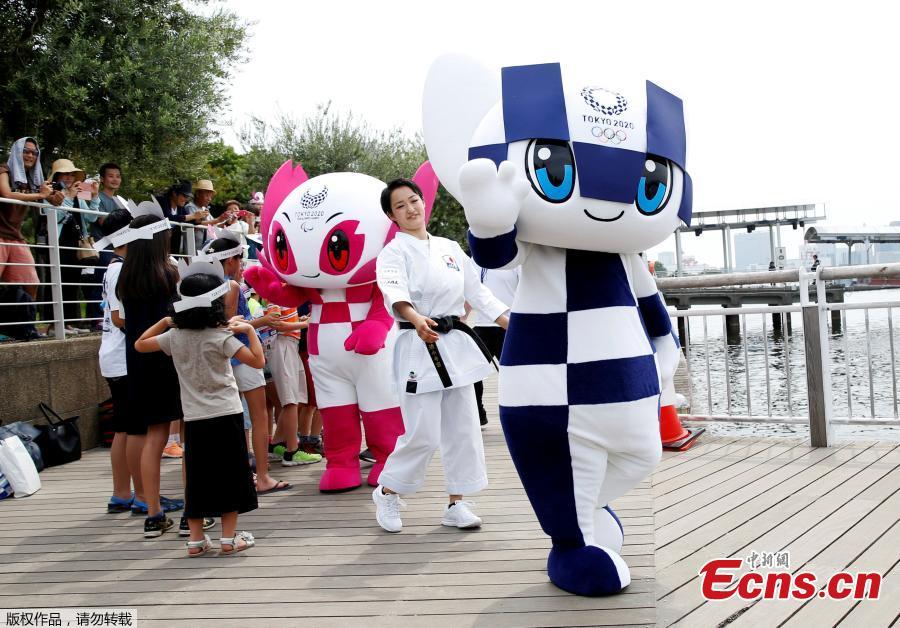 Tokyo 2020 Olympic Games mascot Miraitowa and Paralympic mascot Someity, flanked by Japan\'s karateka Kiyo Shimkizu are greeted by children upon their arrival after their water parade at Odaiba Marine Park in Tokyo, Japan July 22, 2018.  (Photo/Agencies)