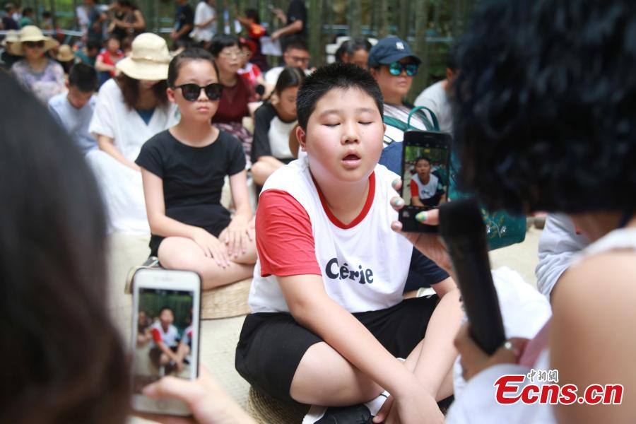 <?php echo strip_tags(addslashes(Blank-faced contestants, including children, sit still and do nothing in a “space-out” contest in Hangzhou City, the capital of East China’s Zhejiang Province, July 21, 2018. Some 100 residents attended the contest, enjoying a moment or two of relaxation. (Photo: China News Service/Liu Peiqi))) ?>