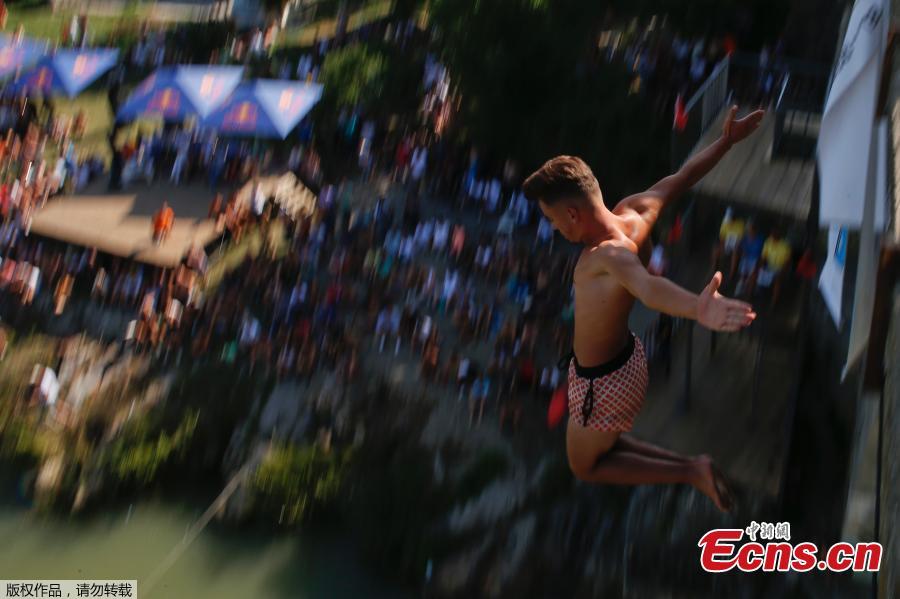 People look at a man as he jumps from the 22 meters high bridge \'Ura e Shenjte\' during the annual traditional High Diving competition near the town of Gjakova on July 22, 2018. (Photo/Agencies)