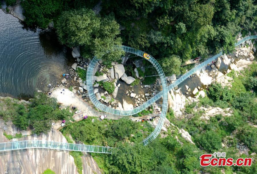 <?php echo strip_tags(addslashes(An aerial view of a waterslide over the Xiangma River in Lushan County, Central China’s Henan Province, July 23, 2018. The 2.3-kilometer-long waterslide around a mountain slope and cliff has a vertical drop of 100 meters, earning it the title of the longest and most challenging waterslide in central China. The thrilling project opened on Monday. (Photo: China News Service/Dong Fei))) ?>