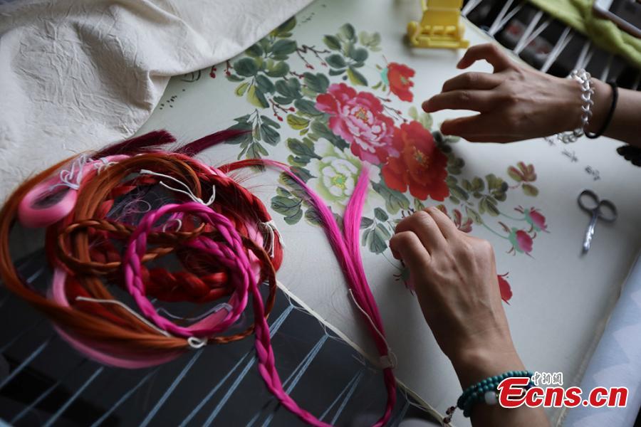 A woman creates a hair embroidery work in Dongtai, Yancheng City of Jiangsu Province, July 22, 2018. Hair embroidery refers to a style of embroidery that uses human hair as thread instead of other materials. According to historical records, hair embroidery originated in Dongtai more than 1,300 years ago. Hair embroidery designs are vivid and varied, involving living creatures, plants, landscapes and historical figures. The art is now included in the provincial-level intangible cultural heritage list. (Photo: China News Service/Yang Bo)