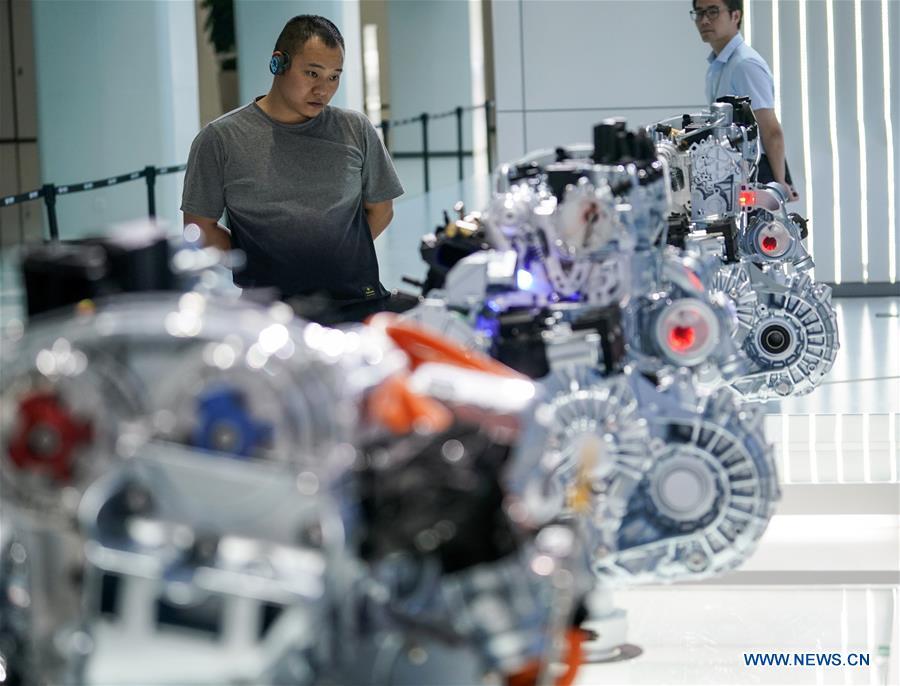 Visitors view engine models at a research and development center of Geely Auto in east China\'s Zhejiang Province, July 3, 2018. This year marks the 40th anniversary of China\'s reform and opening-up policy. (Xinhua/Shen Bohan)