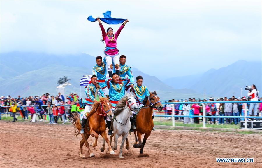 Horsemen perform equestrianism during a traditional ethnic minorities sports meeting held at a racecourse in Sunan Yugur Autonomous County, northwest China\'s Gansu Province, July 28, 2018. (Xinhua/Wang Jiang)