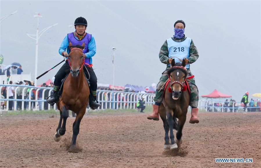 People take part in a horse racing during a traditional ethnic minorities sports meeting held at a racecourse in Sunan Yugur Autonomous County, northwest China\'s Gansu Province, July 28, 2018. (Xinhua/Wang Jiang)