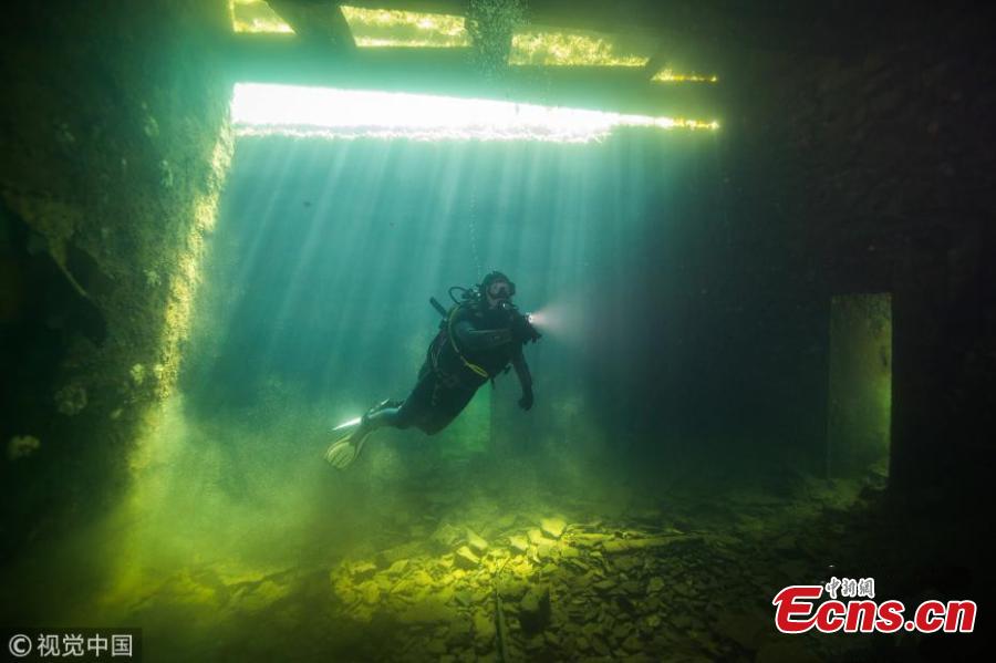 A diver explores Estonia’s Rummu Prison, situated in the middle of a submerged quarry. When Estonia regained its independence in 1991, the Soviets moved out and the labor prison at Rummu was closed. This once eerie place to hold inmates is now an amazingly popular beach where people swim in the deep blue water and dive. (Photo/VCG)
