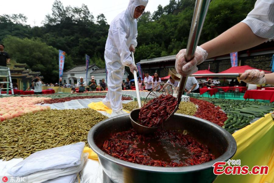 A crayfish banquet is held on Laojun Mountain in Luoyang City, Central China’s Henan Province, July 28, 2018. Organizers prepared more than 1,000 kilograms of crayfish and another 1,000 kilograms of fruit, as well as providing beer, to entertain thousands of visitors, who quickly gobbled up the treats. (Photo/IC)