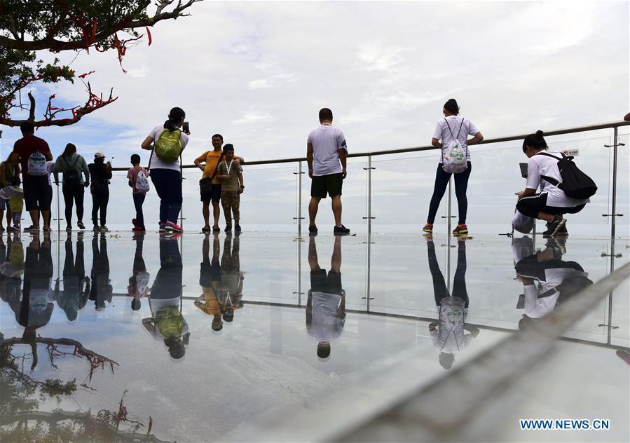 People visit a glass plank road built at the Yalong Bay forest park in Sanya, south China\'s Hainan Province, July 29, 2018. The 400-meter-long plank road will open for tourists in August. (Xinhua/Sha Xiaofeng)