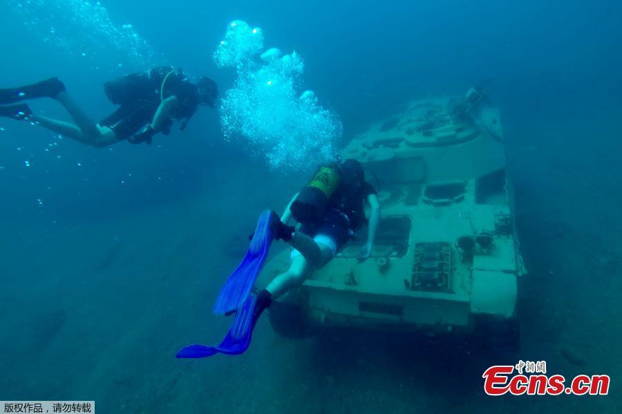Divers swim around immersed tanks off the coast of Sidon, Lebanon, July 28, 2018. Lebanese environmentalists sank 10 old tanks and other armored vehicles to the bottom of the Mediterranean Sea in a novel attempt to attract divers and create new habitats for marine life. (Photo/Agencies)