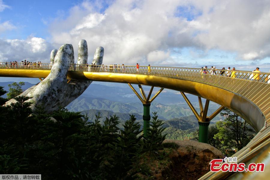 <?php echo strip_tags(addslashes(In this photograph taken on July 31, 2018, visitors walk along the 150-meter long Cau Vang 'Golden Bridge' in the Ba Na Hills near Danang. Nestled in the forested hills of central Vietnam two giant concrete hands emerge from the trees, holding up a glimmering golden bridge crowded with gleeful visitors taking selfies at the country's latest eccentric tourist draw. Suspended 1400 meters above sea level, the bridge combines eight sections and stretches 150 meters long. (Photo/VCG))) ?>