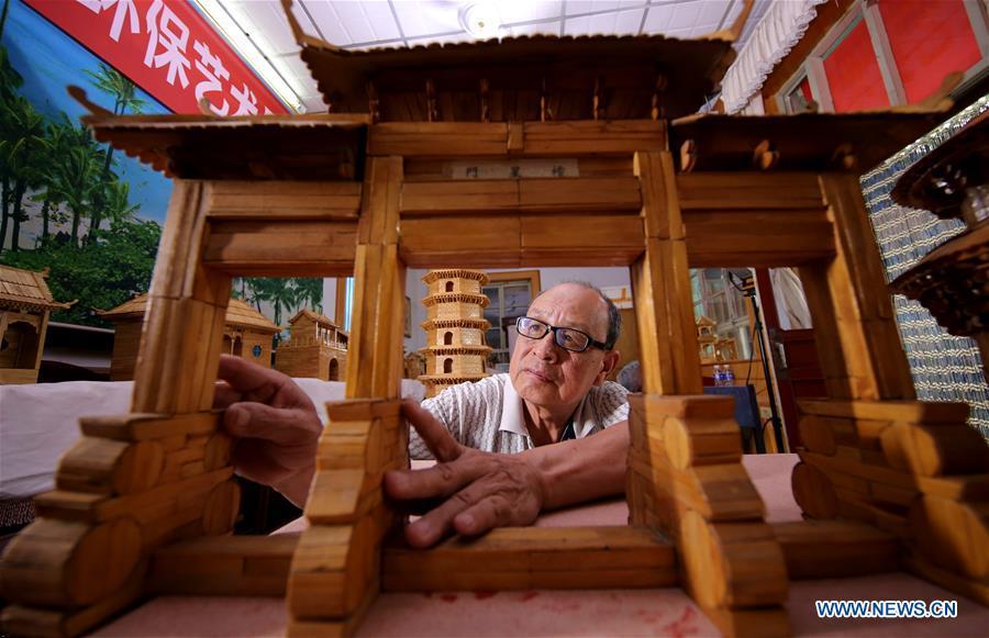 Zhang Xiaocheng checks a model of ancient building made of discarded wooden sticks in Chengguan Town of Wu\'an City, north China\'s Hebei Province, July 31, 2018. 70-year-old Zhang has made over 60 handicrafts using discarded wooden sticks. (Xinhua/Wang Xiao)
