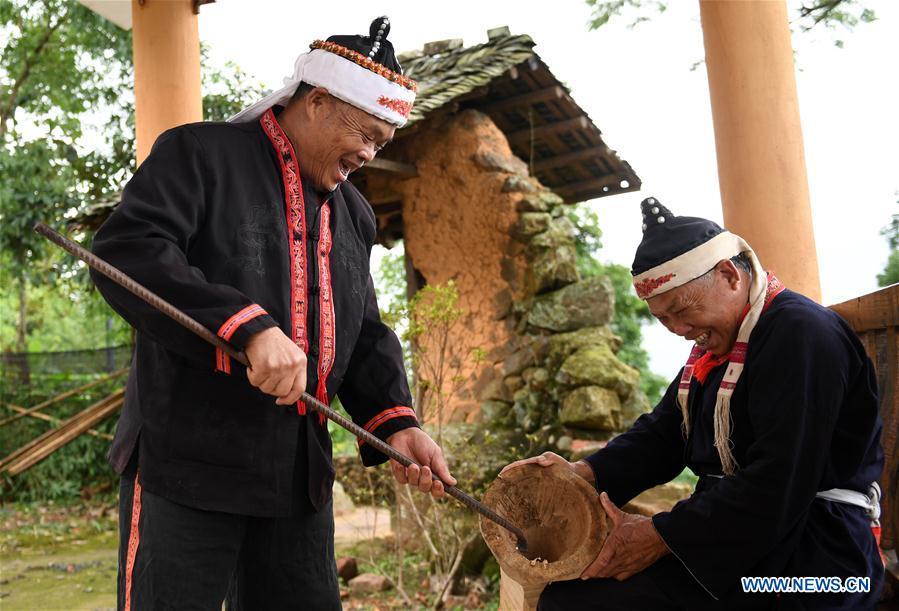 Villagers Pan Zhenwu (L) and Pan Zhiming make a Huangni drum in Jinxiu Yao Autonomous County, south China\'s Guangxi Zhuang Autonomous Region, Aug. 1, 2018. The local Huangni drum dance was listed as one of the national intangible cultural heritage in 2011. (Xinhua/Lu Boan)