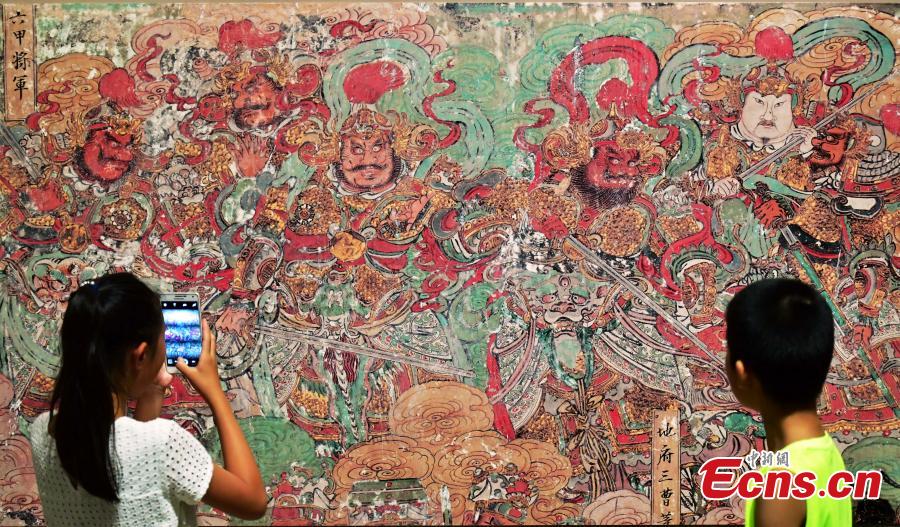 Visitors look at an exhibition of murals at the Hebei Museum in Shijiazhuang City, Hebei Province, Aug. 2, 2018. The murals date back to the Ming Dynasty (1368-1644) and were from the Pilu Temple. They are known for their great composition, superb craftsmanship and rich connotation. (Photo: China News Service/Zhai Yujia)