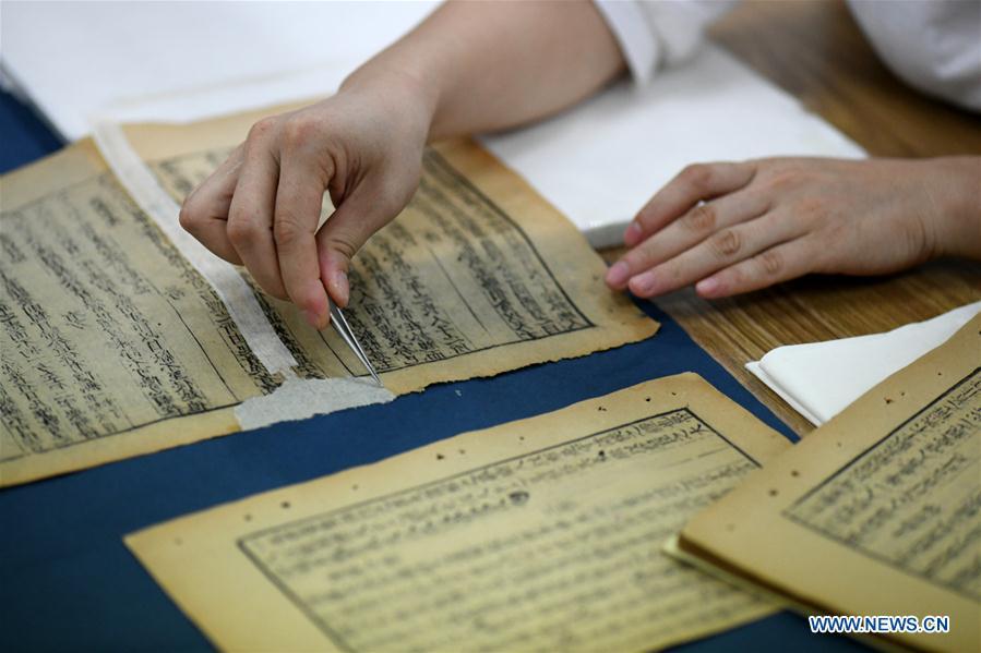 Gao Huiyun restores an ancient book at a workshop in Shijiazhuang, capital of north China\'s Hebei Province, Aug. 2, 2018. Gao Huiyun is a teacher of cultural relics restoration and protection at Hebei Vocational Art College. Gao has restored over 1,000 ancient books in her 13-year career time. (Xinhua/Chen Qibao)