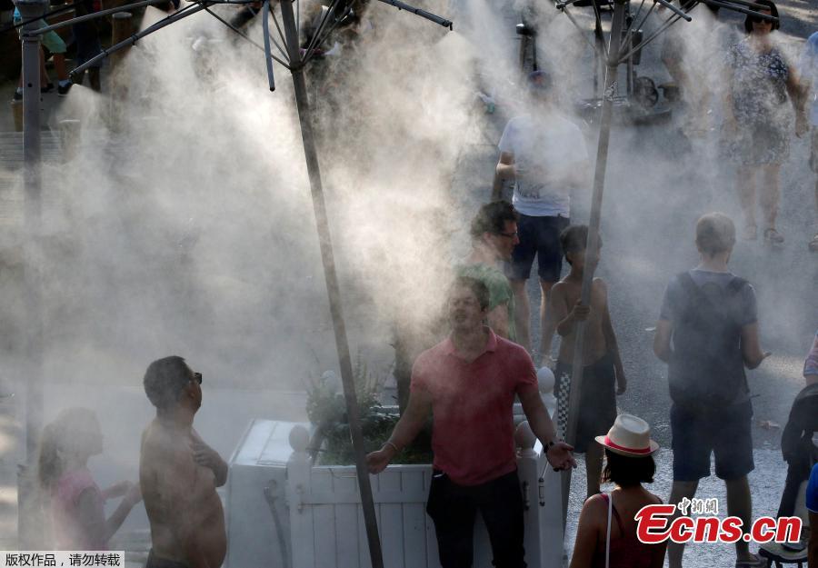 <?php echo strip_tags(addslashes(People stand in a spray water to cool off as a summer heatwave with high temperatures continues in Paris, France, August 4, 2018. Europe’s heatwave gripped Spain and Portugal on Friday, as governments checked for forest fires, a Budapest game reserve fed its animals iced snacks and a Finnish supermarket invited customers to sleep over to stay cool. (Photo/Agencies))) ?>
