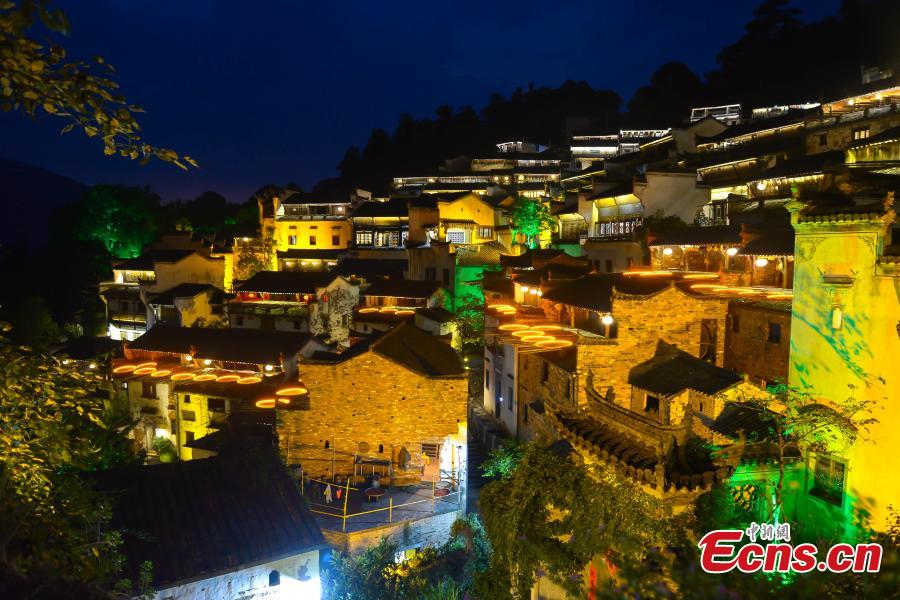 Nearly 1,000 visitors enjoy a long banquet along a street in the ancient Huangling village in Wuyuan, East China’s Jiangxi Province, Aug. 4, 2018. The connected tables stretched for hundreds of meters, and local dishes were served up for tourists. (Photo: China News Service/Fang Huabinb)