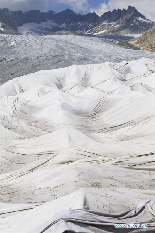 <?php echo strip_tags(addslashes(Photo taken on Aug. 5, 2018 shows the Rhone Glacier covered with white blankets near the Furka Pass in Switzerland. The Rhone Glacier is protected by special white blankets to prevent it from further melting as a result of global warming. (Xinhua/Xu Jinquan))) ?>