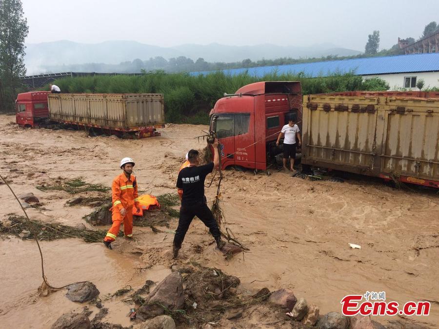 Rescuers help a driver escape from a truck trapped by mountain torrents in Fudian Town, Yanshi City, Central China’s Henan Province, Aug. 5, 2018. Fifteen drivers were saved after a flash flood caused by a two-hour rainstorm trapped 50 trucks. (Photo/VCG)