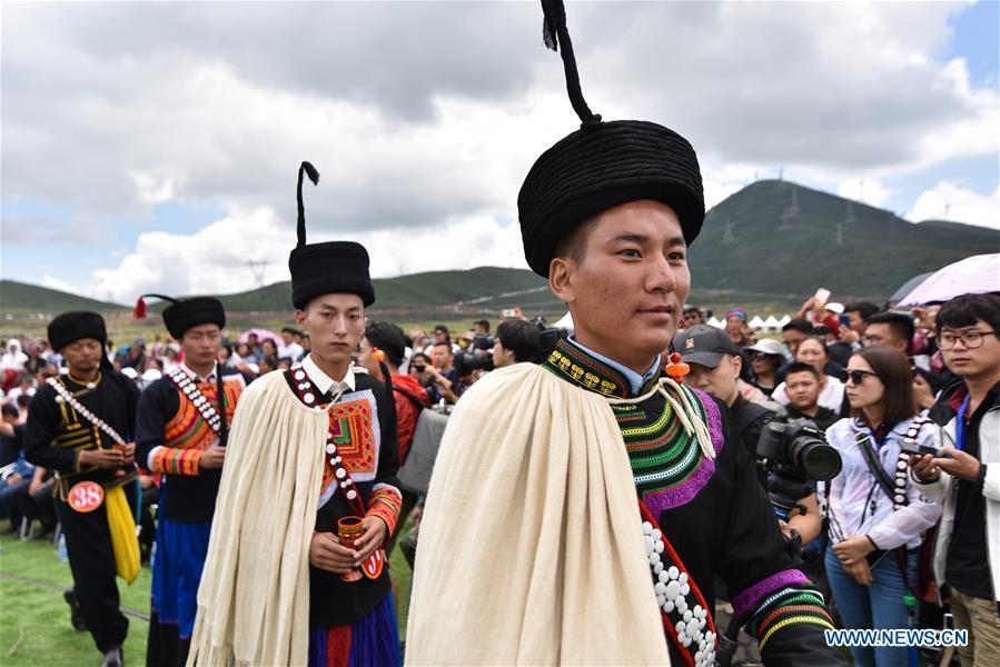 <?php echo strip_tags(addslashes(Contestants offer local wine for guests during a beauty contest of the torch festival of Yi ethnic group on a grassland in Zhaojue County, southwest China's Sichuan Province, Aug. 6, 2018. (Xinhua/Lyu Mingze))) ?>