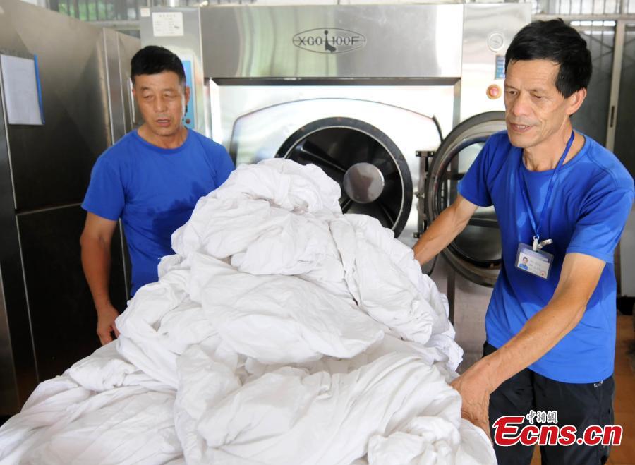 Workers clean bedding for sleeper carriages on trains in Jiujiang City, East China’s Jiangxi Province, Aug. 8, 2018. During the summer travel peak, laundry service workers have to clean up to 20,000 sets of linen a day, double their normal workload, despite the high temperatures at 50 degrees centigrade. (Photo: China News Service/Hu Guolin)