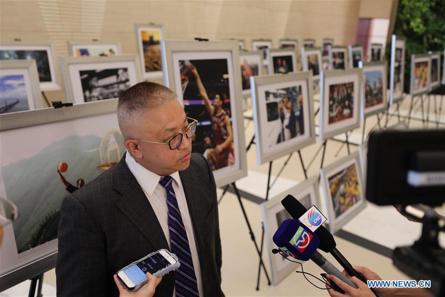 Huang Xiaojun, Executive Vice President of New York Branch, Bank of China, is interviewed at the photo exhibition \
