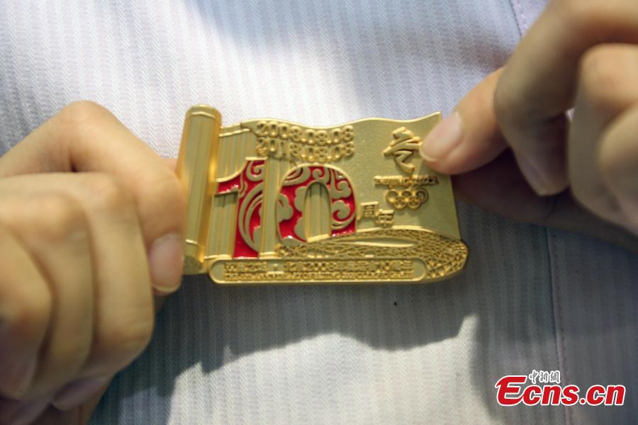 One of the nine sets of souvenirs released by the Beijing Organizing Committee for the 2022 Olympic and Paralympic Winter Games to mark the 10thanniversary of Beijing’s hosting of the 2008 Summer Olympics, Aug. 8, 2018. The souvenirs include badges, a commemorative envelope and stamp albums. (Photo: China News Service/Ren Haixia)