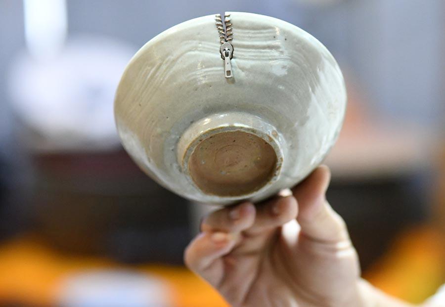 <?php echo strip_tags(addslashes(A broken porcelain ware is restored with an artistic touch, resembling the look of a zip. (Photo/Xinhua))) ?>