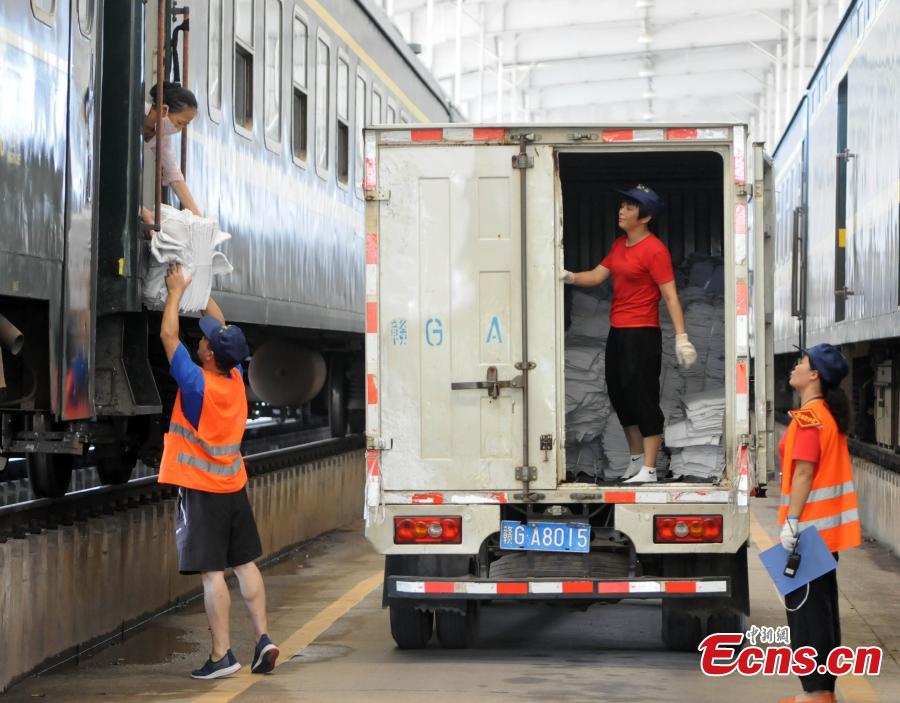 Railway workers transport clean bed linen destined for sleeper carriages on trains in Jiujiang City, East China’s Jiangxi Province, Aug. 8, 2018. During the summer travel peak, laundry service workers have to clean up to 20,000 sets of linen a day, double their normal workload, despite the high temperatures at 50 degrees centigrade. (Photo: China News Service/Hu Guolin)