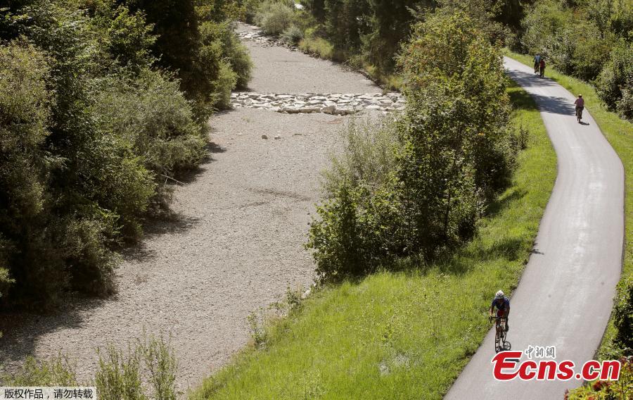 People cycle during hot summer weather along the dried river bed of the Toess river near the village of Wila, Switzerland, August 9, 2018. (Photo/Agencies)