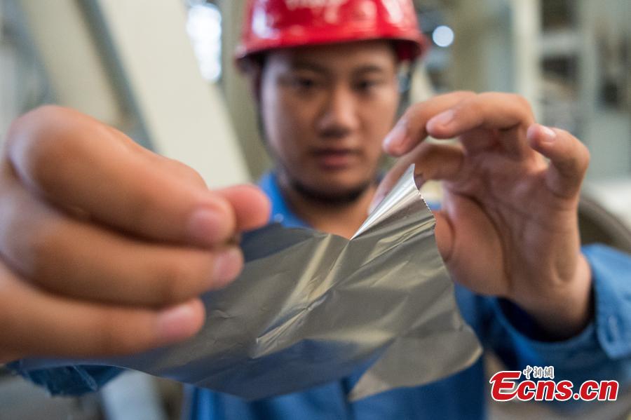 A worker shows stainless steel 0.02 millimeters thick at a company in Taiyuan City, the capital of North China’s Shanxi Province, Aug. 8, 2018. The company started mass production of the advanced 0.02-millimeter-thick, 600-millimeter-wide stainless steel, which is said to have wide applications in a range of fields, including aerospace, automotive, electronics and computers. Sources said due to difficult production techniques, China used to import the product from Japan and Germany. (Photo: China News Service/Wei Liang)