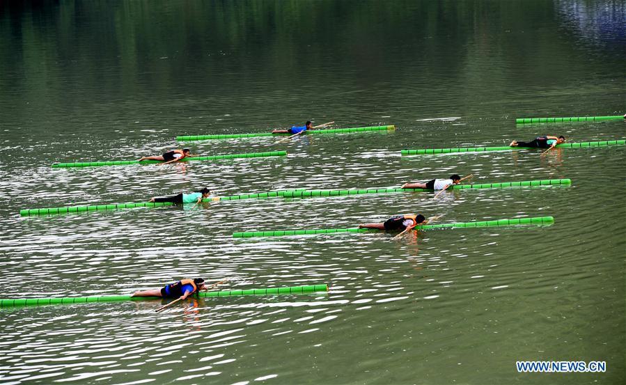 Middle school students practice single bamboo drifting on water in Rongjiang County, southwest China\'s Guizhou Province, Aug. 11, 2018. Single bamboo drifting originated in China\'s Guizhou and requires a person to stand or sit on a single piece of bamboo while performing graceful movements. (Xinhua/Wang Bingzhen)