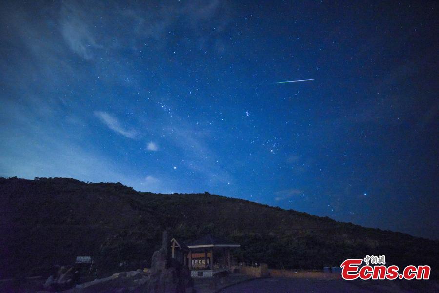 A meteor streaks past stars in the night sky during the Perseid meteor shower in Hong Kong, August 13, 2018. (Photo: China News Service/ Sheung Man Mak)
