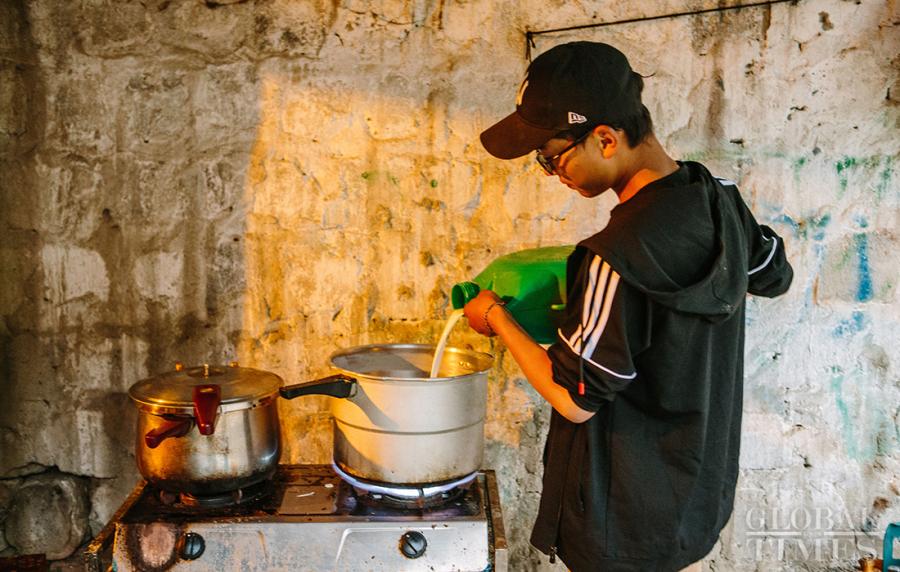 A man prepares to boil the fresh yak milk by pouring it into a pot. (Photo: Li Hao/GT)