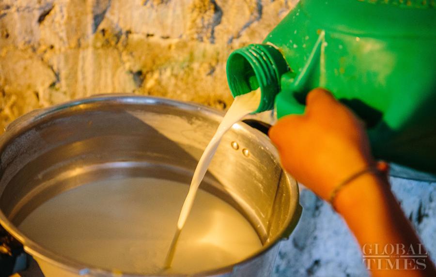 A man prepares to boil the fresh yak milk by pouring it into a pot. (Photo: Li Hao/GT)