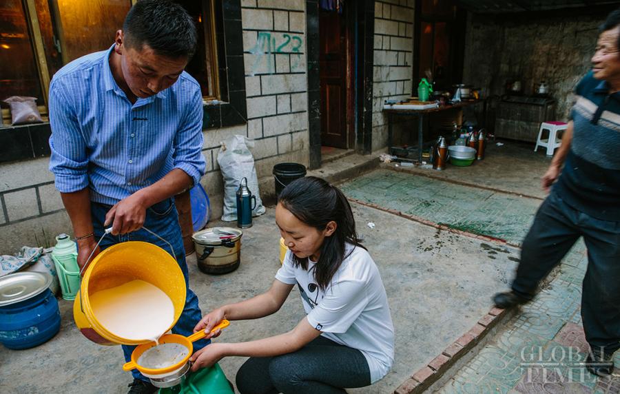 Locals pour the fresh yak milk into a jar. (Photo: Li Hao/GT)