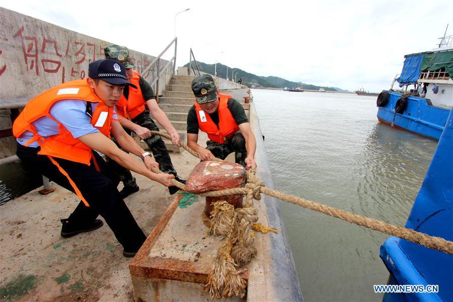 Frontier guards and local police help reinforce fishing boats at a dock in the Luqiao District of Taizhou City, east China\'s Zhejiang Province. China\'s national observatory on Sunday upgraded the alert for typhoon Yagi from blue to yellow, as the typhoon is forecast to make landfall in the eastern coastal region Sunday night. (Xinhua/Jiang Youqin)