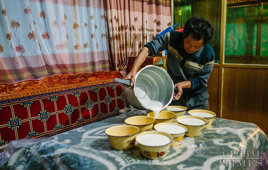 The boiled milk is transferred to several small bowls to help it cool down.  (Photo: Li Hao/GT)