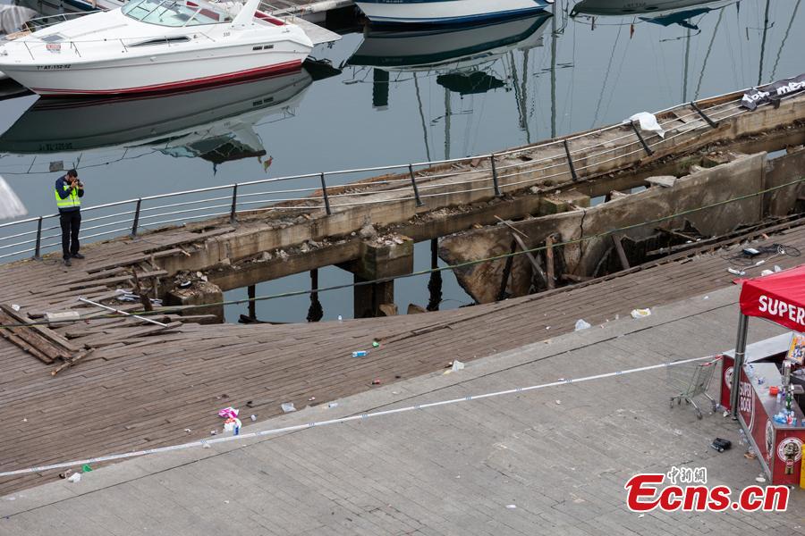 A police investigator inspects the seafront platform in Vigo on August 13, 2018 after a section of a wooden promenade suddenly collapsed with people watching a rap artist just before midnight on Sunday. More than 300 people were injured, including nine seriously, the regional government of Galicia said in a statement. (Photo/Agencies)