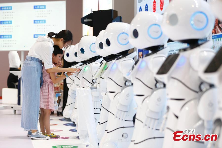 Visitors look at robots on display at the World Robot Conference 2018 in Beijing, Aug. 15, 2018. The conference included a competitive section, which attracted contestants from 16 countries and regions. (Photo: China News Service/Fu Tian)